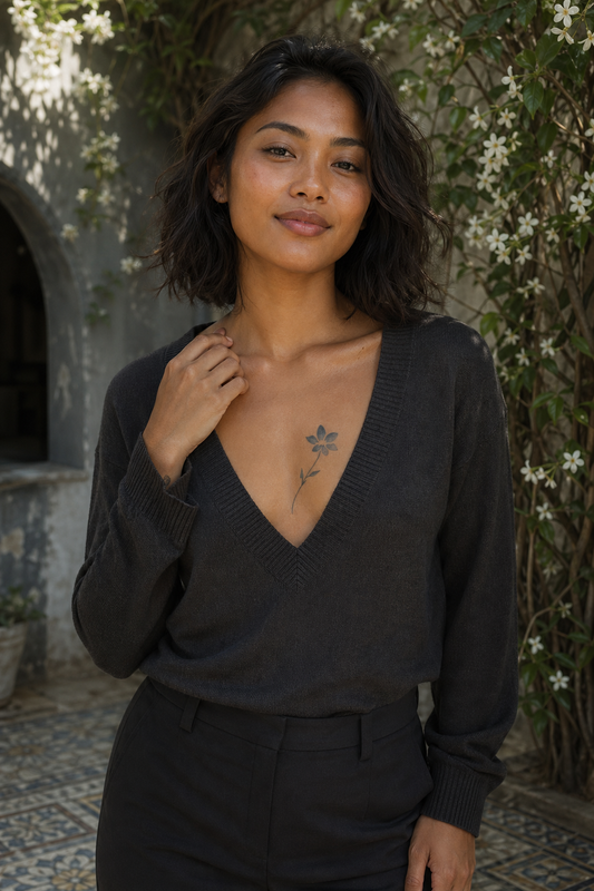 Petite Fleur des Montagnes. a small wildflower with six rounded petals around a compact center, with a thin curved stem and two pointed leaves, poitrine, soft late-morning light filtered through jasmine vines.