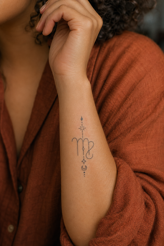 Kanya de la Vierge. stylized Virgo-like zodiac glyph with star and moon elements, thin clean strokes, dots and small diamond/star shapes, inner forearm, overcast diffuse Parisian light, no harsh shadows.